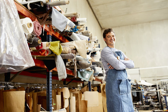 Worker Standing Arms Crossed By Shelves At Sofa Workshop