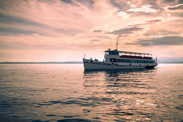 Obraz premium Ferry on Lake Garda at sunset.