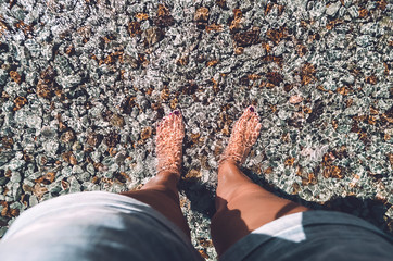recovery. vacation. sea water. summer . stones underfoot. feet barefoot in the water