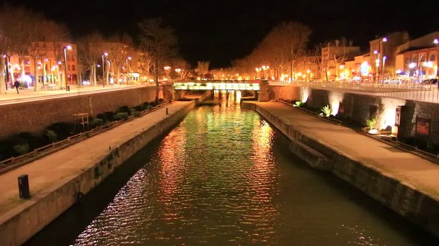 Quai on the edge of the Canal du Midi in the city of Narbonne at night, Aude in southern France
