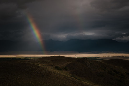 Landscape with rainbow in darkness