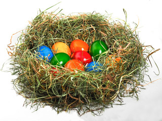 Bunte Ostereier im Nest aus Heu (Osternest) auf weißem Hintergrund