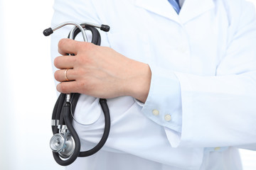 Close Up of Unknown male doctor standing straight while holding stethoscope. Medicine and health care concept