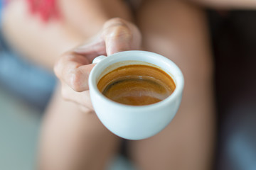 Hot espresso coffee on women hand holder