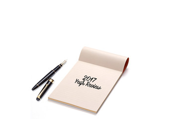 Notebook with pen on white background writing 2017 Year Review