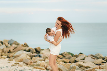 Young beautiful mother and her son having fun on the beach