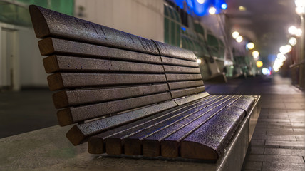 Wood sitting bench on pier, facing the ocean.