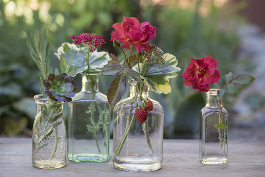 Close-up of small flowers in glass jars