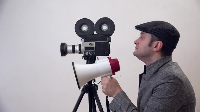Portrait of man with video camera , director talking on megaphone