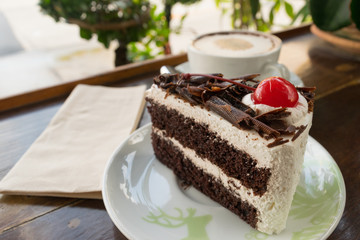 cake chocolate and blur coffee cup on table wood background