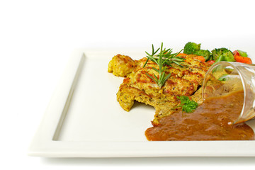 Grilled Chicken Steak top with rosemary with a glass of black pepper gravy, potato and mix vegetable in white plate on white background