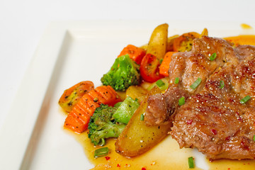 Thai cuisine north eastern style, fusion food grilled pork steak spicy salad serve with mix vegetable and fried potatoes on white background