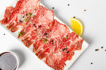 Raw beef sliced, japanese beef sliced "Wagyu" in white plate top view on white background