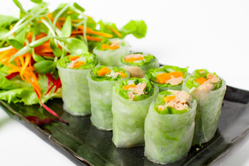 Fresh Tuna spring roll, traditional vietnamese food serve with mix vegetable in black plate on white background