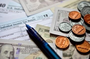 Tax form with notepad, pen and calculator on table. 