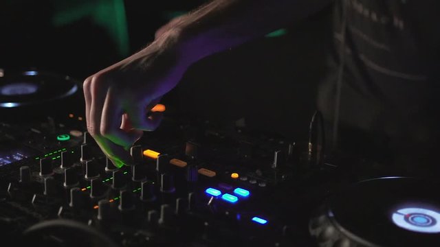 DJ hands on mixer and decks