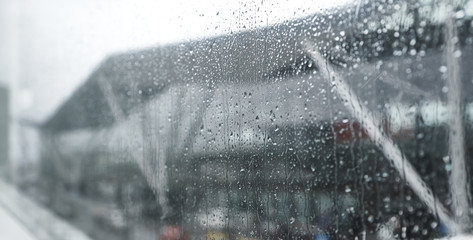 View of the airport through wet glass. Stock image. Airport seen blurred through window glass with raindrops.