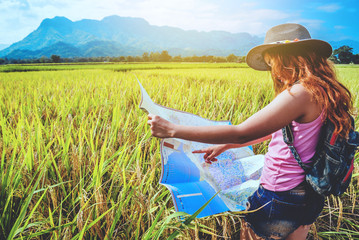 Asian women travel relax in the holiday. Stand natural touch mountain field summer. View map travel explore. In Thailand