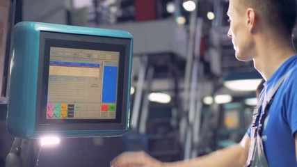 Engineer chooses factory equipment options using touchscreen of an industrial machine. - Powered by Adobe