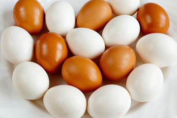 a lot of white and brown eggs on a white plate