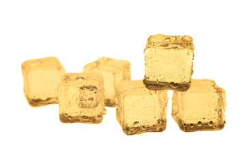 Golden ice cubes on white background.