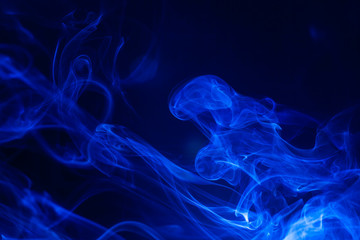 Blue smoke on black background.