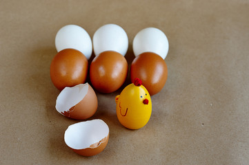 toy chicken, broken shell, a row of white and brown eggs