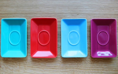 Colorful plates on a wooden background