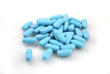 Obraz na płótnie Canvas Oval blue tablets closeup on white background