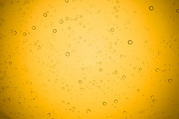 Water drops on yellow glass, Rain droplets on glass background.