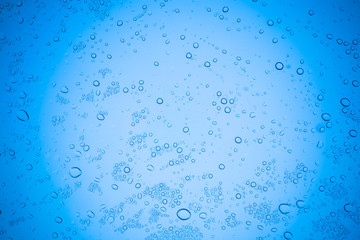 Rain droplets on blue glass background, Water drops on glass.