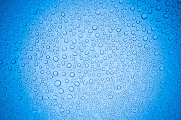 Rain droplets on blue glass background, Water drops on glass.