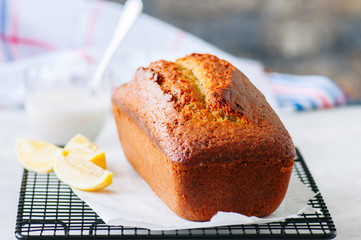 Homemade lemon poppy seed pound cake on a wire rack. White stone background.