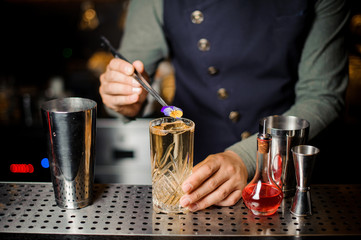 Barman decorating a sweet alcoholic cocktail with a flower