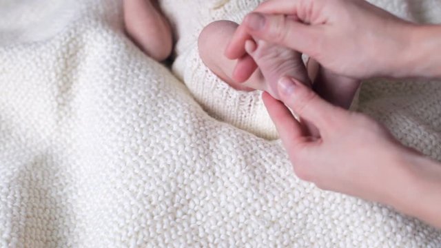 Baby feet massage. Newborn feet in mother hands