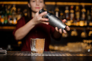 Cocktail glass decorated with cinnamon on the blurred background of barman