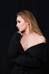 Naklejka premium Profile of sexy lady with glamour makeup and long blonde hair in long coat posing in studio, dark background. Elegant woman. Erotic noir concept.