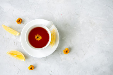 A cup of red herbal tea on a white stone backdrop. Copy space and top view.
