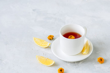 A cup of red herbal tea on a white stone backdrop. Copy space.