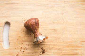 top view coffee tamper for coffee on a wooden board with space