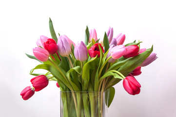 closeup of colorful bouquet of tulips in a transparent vase