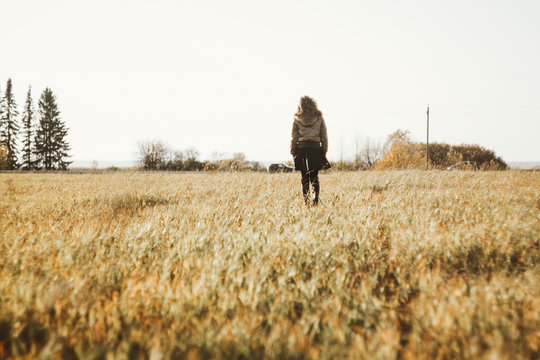 Girl is walking in the field in autumn