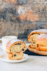 Reindling - Austrian or German festive yeasty baking for Easter. Ring cake served on a wooden plate on a white stone background.