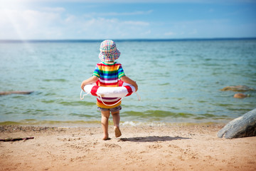 little boy playing at the beach in hat
