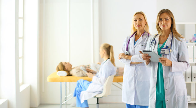 Attractive female doctor in front of medical group