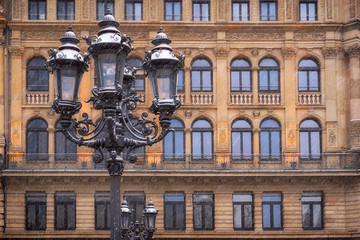 Fototapeta na wymiar alte Lampe mit Gebäude im Hintergrund