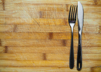 Silver Knife and fork on wooden table with copy space. top view