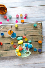 Easter eggs on a wooden background with paints
