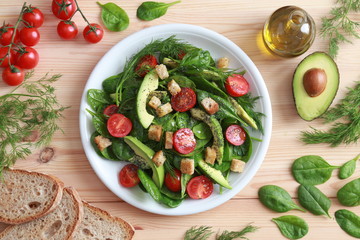 mixed salad dish with avocado and tomato top view