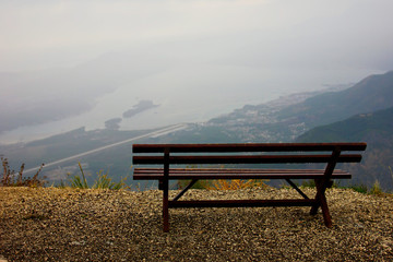 Romantic lonely bench on the top of the mountains overlooking the Bay on a trip to Montenegro in the rain and cloudy weather